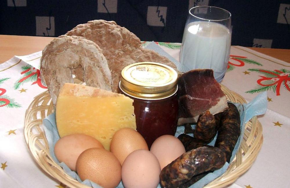 Korb mit Brot, Speck, Wurst, Käse, Marmelade, Eier und Milch vom Hof Korb mit Brot, Speck, Wurst, Käse, Marmelade, Eier und Milch vom Hof